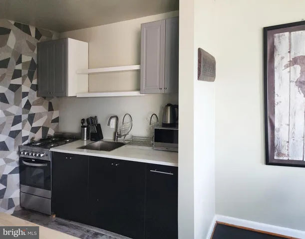 a kitchen with a sink a stove and cabinets