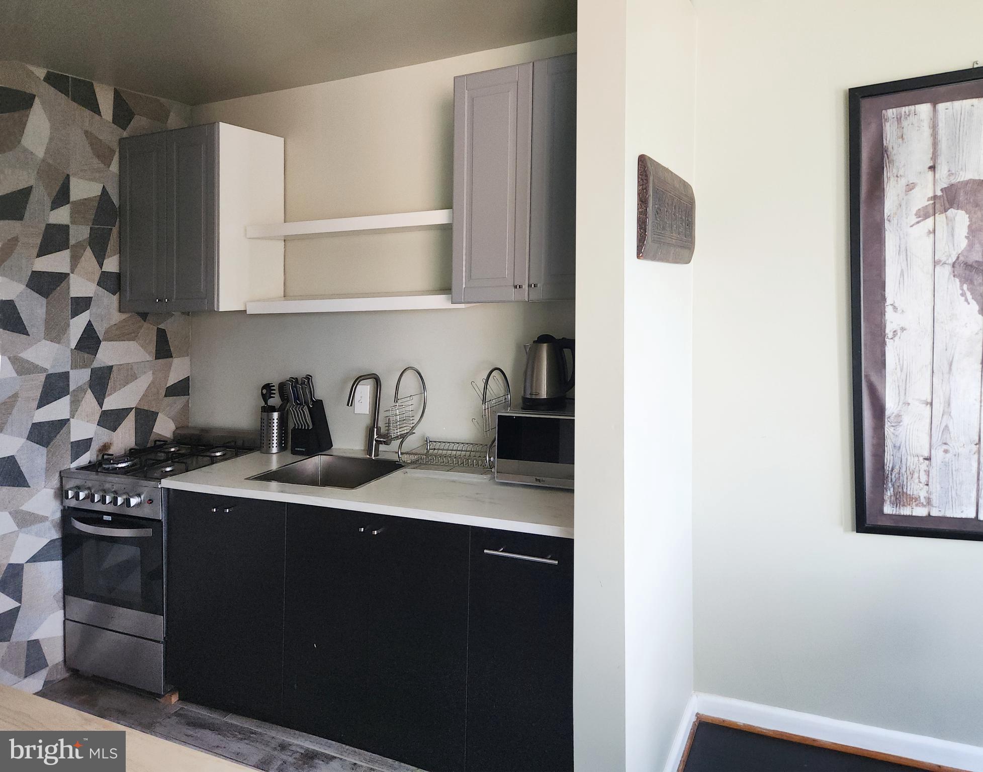 4201 Cathedral Avenue Northwest, Unit 1418E Washington, DC 20016 - Photo 8 of 17 a kitchen with a sink a stove and cabinets