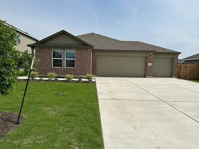 a front view of a house with a garden and yard