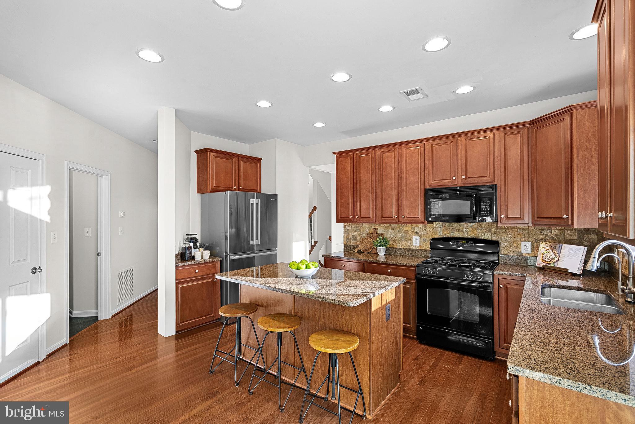 809 Devonshire Circle Purcellville, VA 20132 - Photo 9 of 36 a kitchen with stainless steel appliances granite countertop wooden cabinets a stove top oven a sink and dishwasher