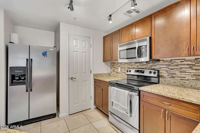 a kitchen with stainless steel appliances granite countertop a stove a refrigerator and a microwave