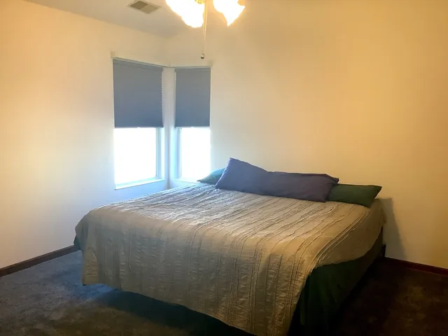 a bed sitting in a bedroom next to a window