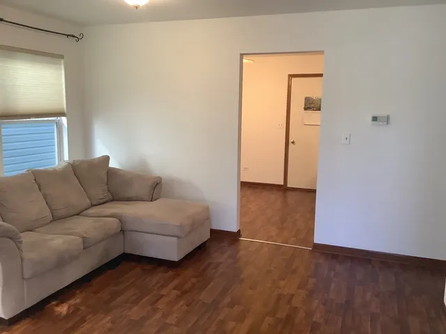 a living room with furniture and a hard wood floor