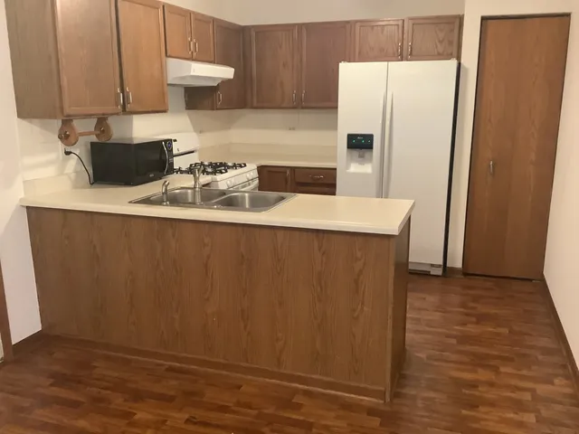 a kitchen with a sink a refrigerator and cabinets