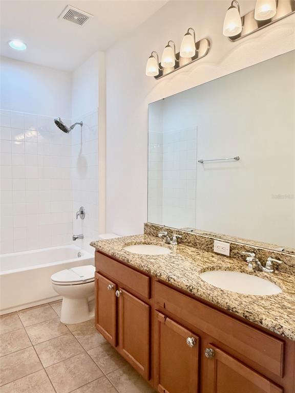 619 Fortanini Circle Ocoee, FL 34761 - Photo 23 of 36 a bathroom with a granite countertop sink a toilet and bathtub