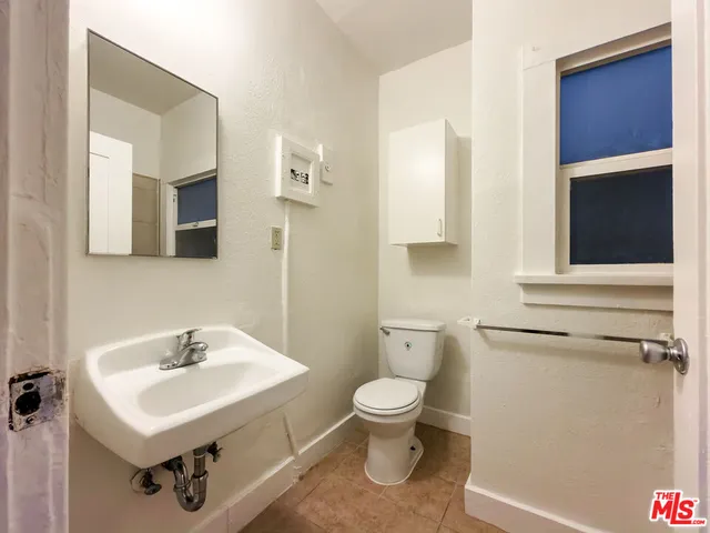 a bathroom with a sink a toilet and mirror