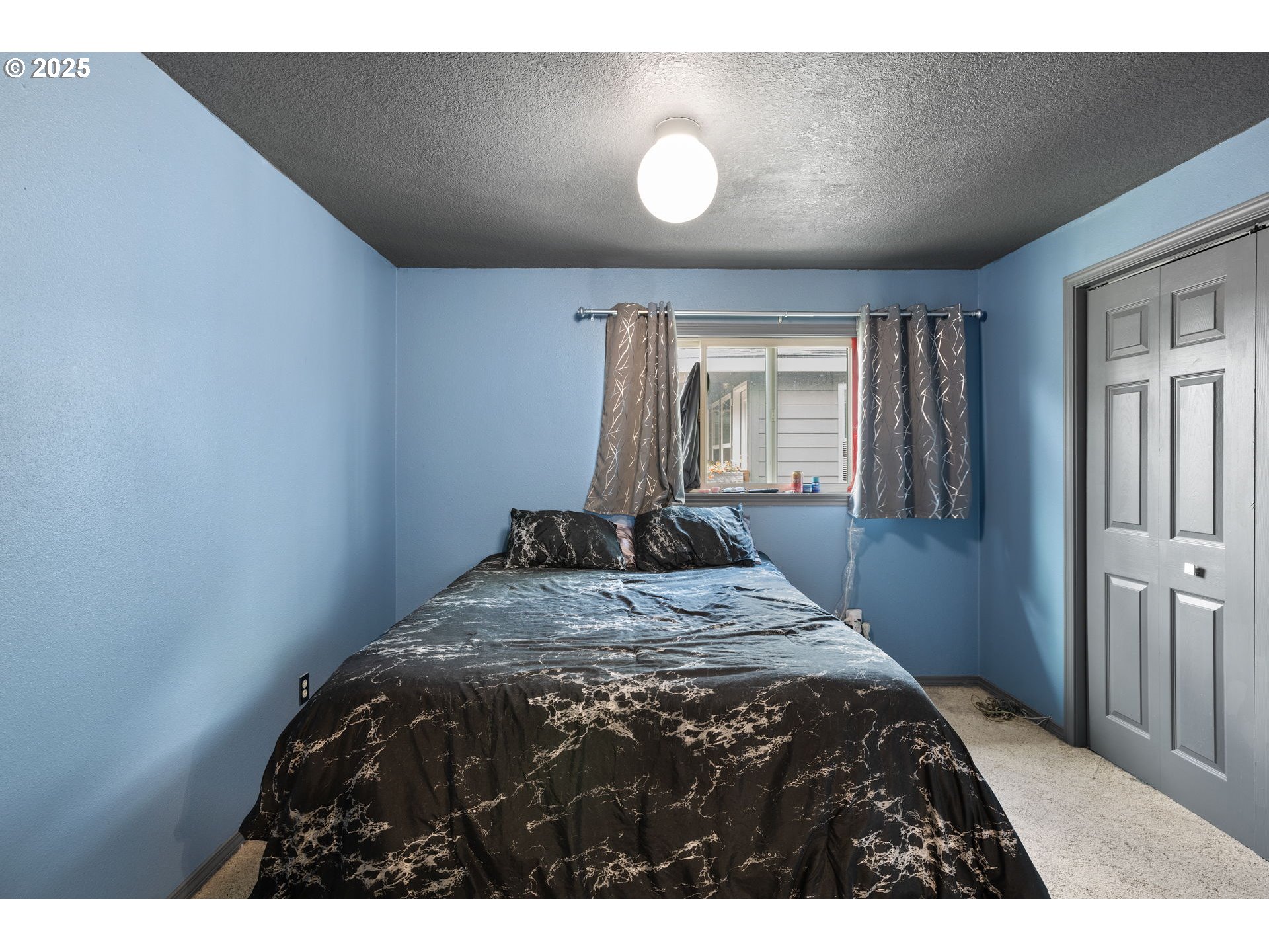 480 Northwest Norman Avenue Gresham, OR 97030 - Photo 17 of 40 a bed sitting in a bedroom next to a window