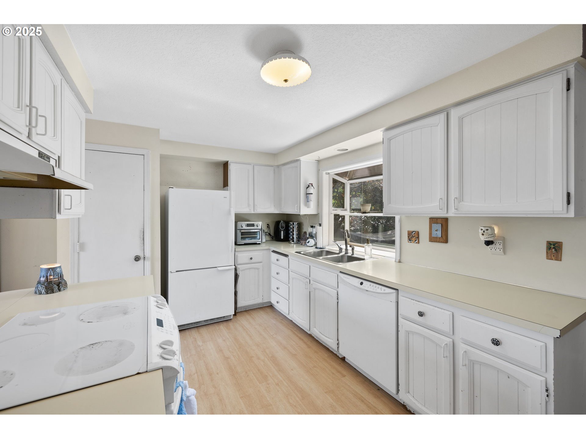 480 Northwest Norman Avenue Gresham, OR 97030 - Photo 7 of 40 a kitchen with white cabinets and white appliances