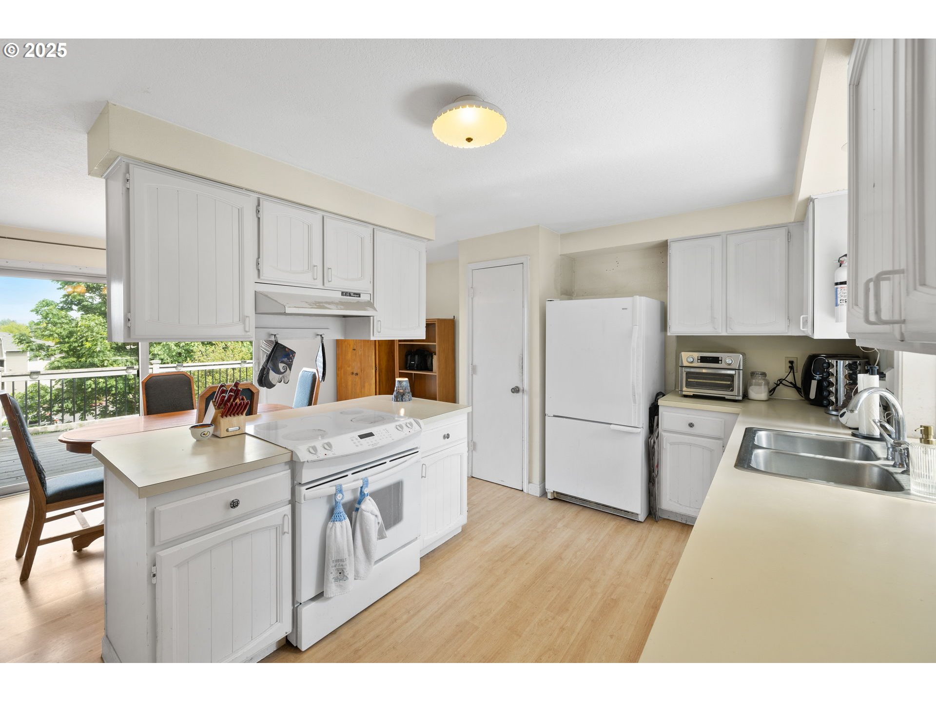480 Northwest Norman Avenue Gresham, OR 97030 - Photo 10 of 40 a kitchen with a sink a stove a refrigerator a center island and cabinets
