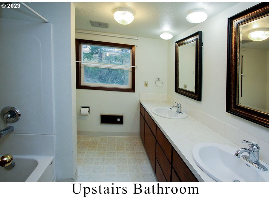 2514 Northwest 209th Street Ridgefield, WA 98642 - Photo 27 of 32 a bathroom with a sink a mirror and a bathtub