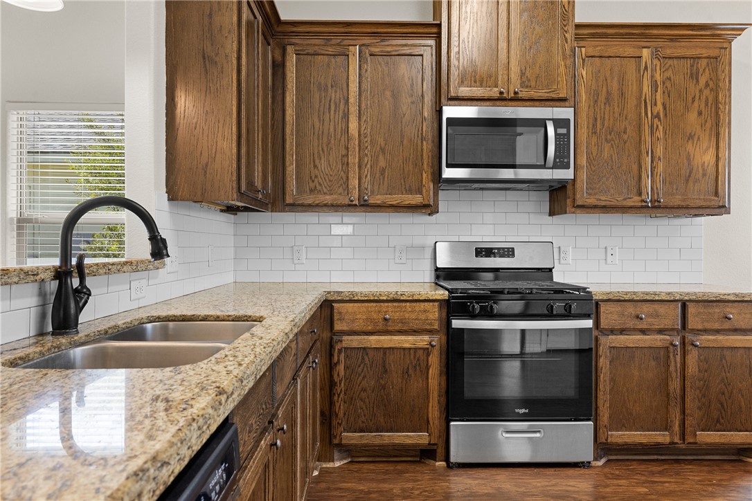 930 West 28th Street Bryan, TX 77803 - Photo 20 of 30 a kitchen with sink a microwave and cabinets