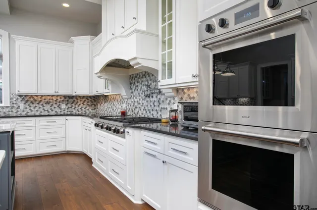 a kitchen with granite countertop white cabinets and white appliances