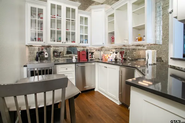 a kitchen with stainless steel appliances granite countertop a sink dishwasher stove and cabinets