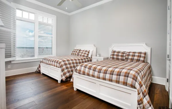 a bedroom with two beds and wooden floor