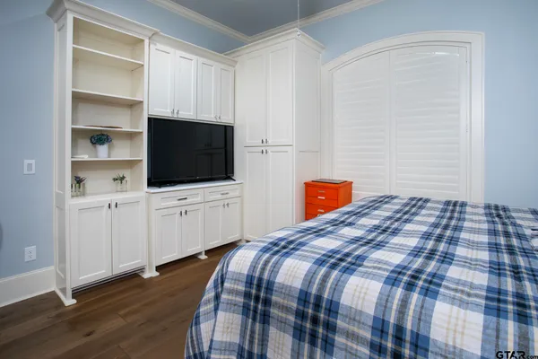 a bedroom with bed and flat tv screen on dresser