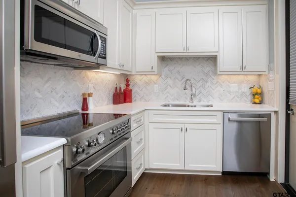 a kitchen with stainless steel appliances granite countertop a sink and a microwave