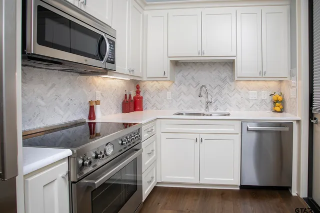 a kitchen with stainless steel appliances granite countertop a sink and a microwave