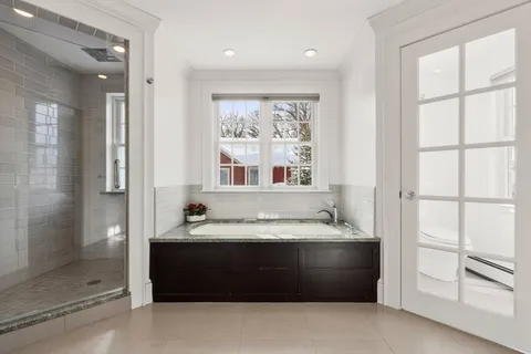 a bathroom with a tub a sink and a shower