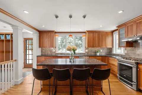 a kitchen with granite countertop a stove a sink and a refrigerator