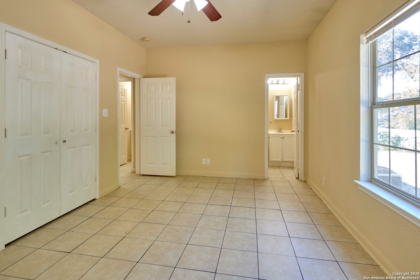 10911 Baltic Drive, Unit 102 San Antonio, TX 78213 - Photo 18 of 23 a view of an empty room with window and chandelier fan