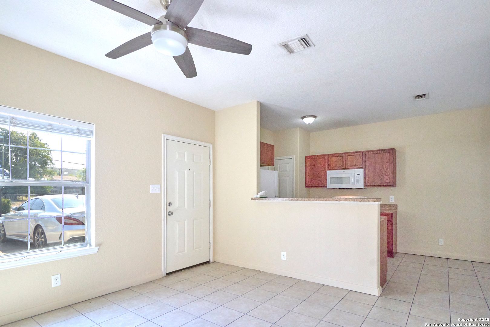 10911 Baltic Drive, Unit 102 San Antonio, TX 78213 - Photo 6 of 23 a view of a kitchen with an empty space and a ceiling fan