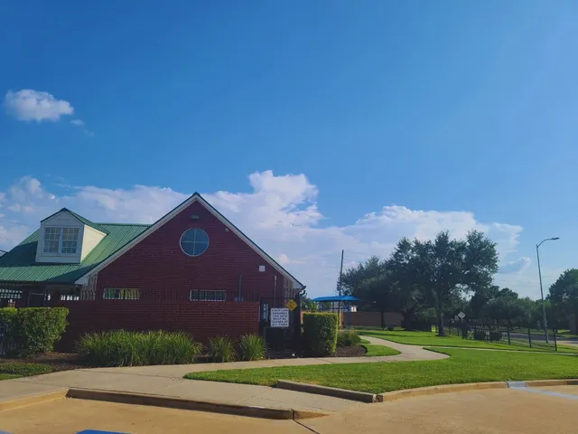 a view of a big building with a big yard and large trees