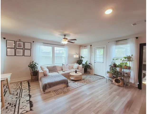 a living room with furniture and wooden floor