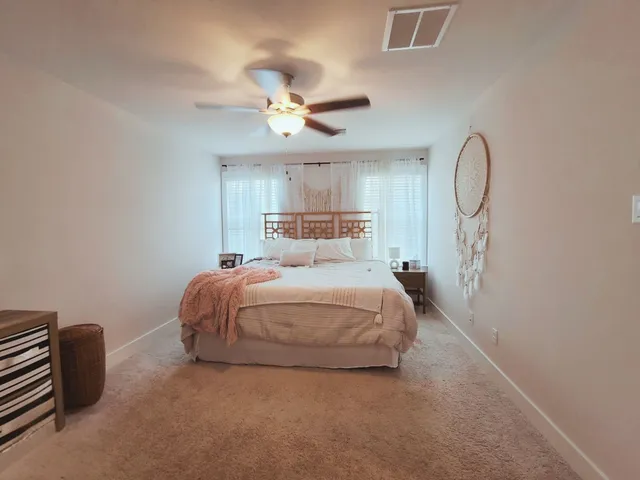a bedroom with a bed lamp and a chandelier