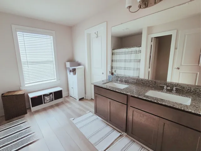 a spacious bathroom with double vanity and a large mirror