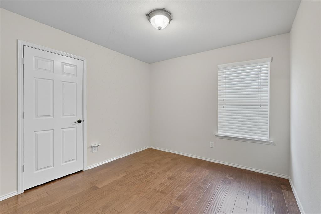 9822 Revolution Way Frisco, TX 75033 - Photo 18 of 29 an empty room with wooden floor and windows