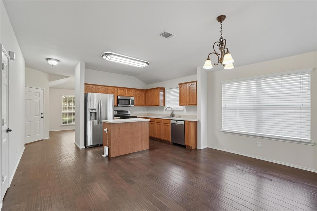 9822 Revolution Way Frisco, TX 75033 - Photo 3 of 29 a large kitchen with stainless steel appliances granite countertop a refrigerator a sink dishwasher a oven and a dining table with wooden floor