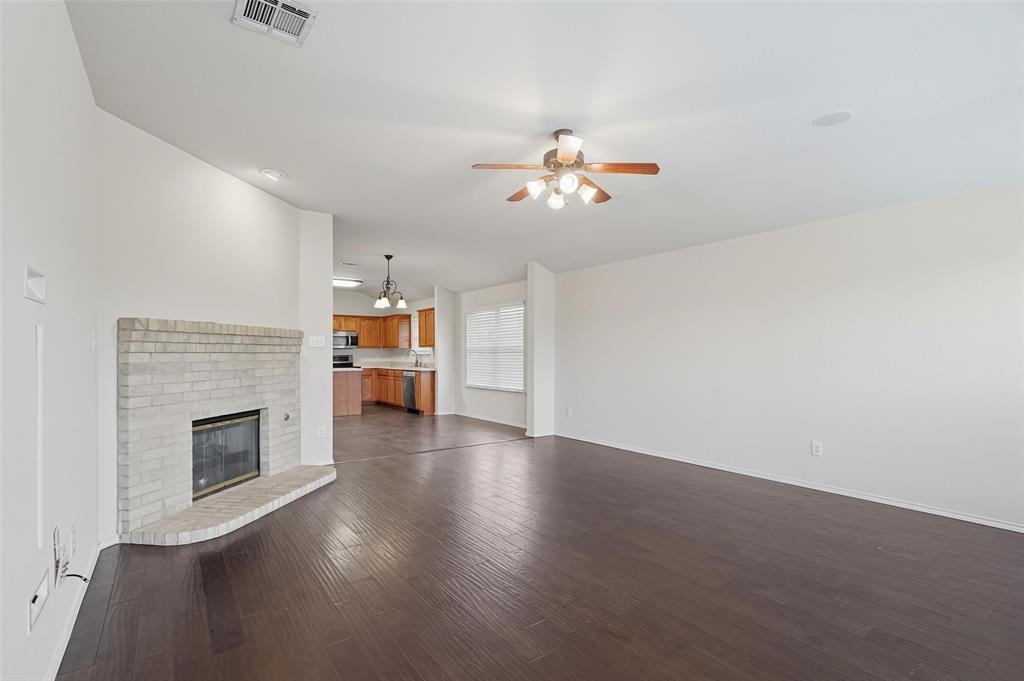 9822 Revolution Way Frisco, TX 75033 - Photo 6 of 29 an empty room with wooden floor fireplace and cabinet