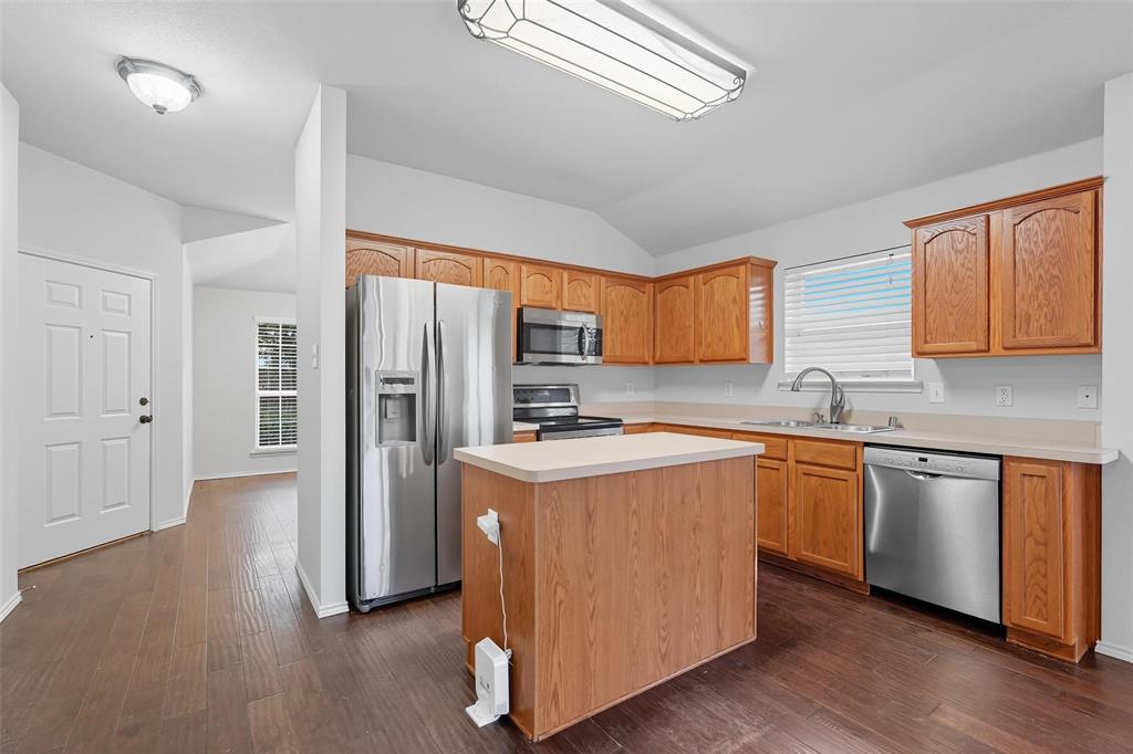 9822 Revolution Way Frisco, TX 75033 - Photo 7 of 29 a kitchen with stainless steel appliances granite countertop a refrigerator a sink dishwasher a stove and white countertops with wooden floor
