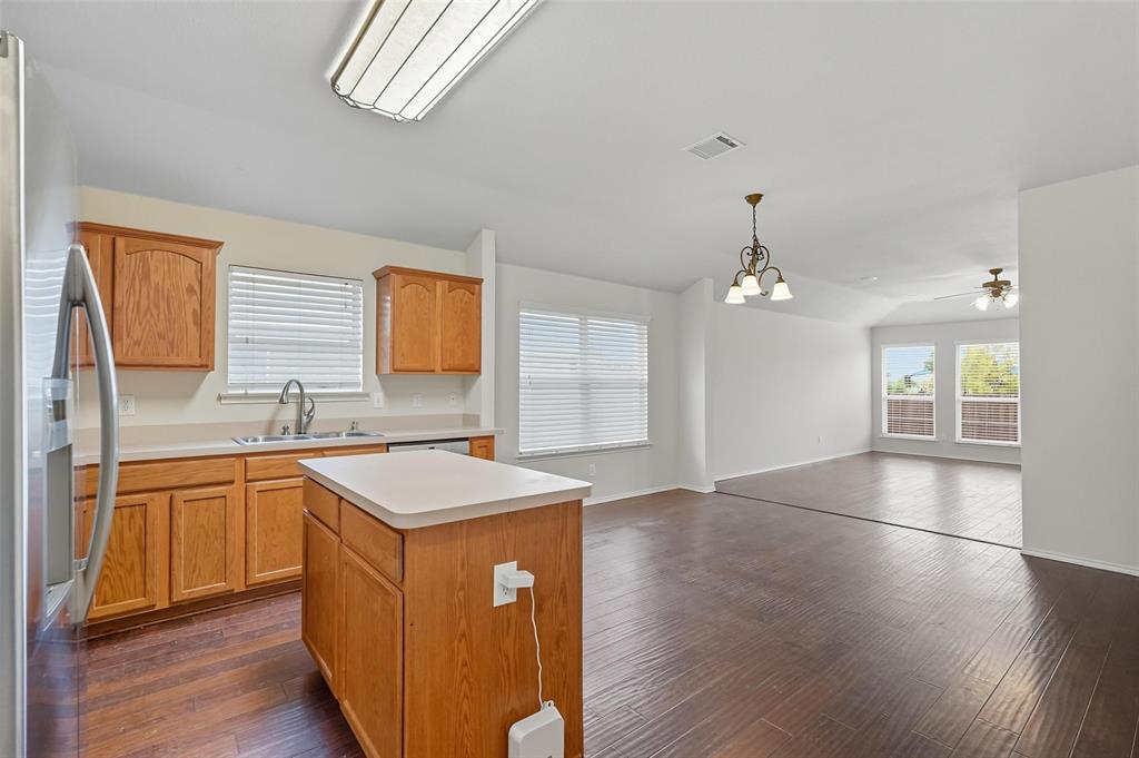 9822 Revolution Way Frisco, TX 75033 - Photo 8 of 29 a kitchen with stainless steel appliances granite countertop a sink stove and wooden floor