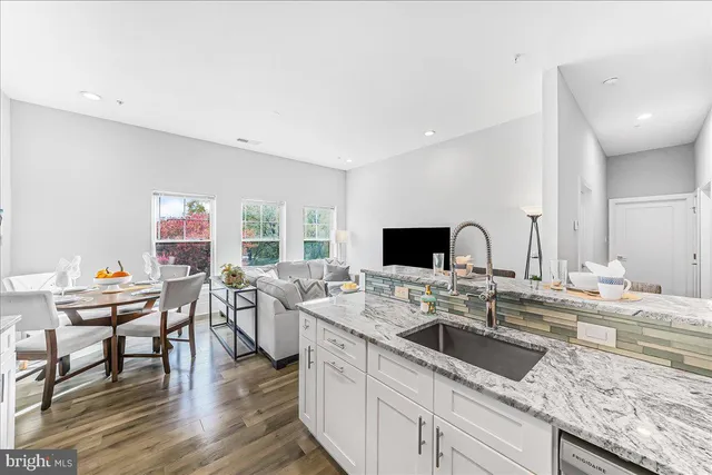 a kitchen with a sink and a stove top oven with wooden floor