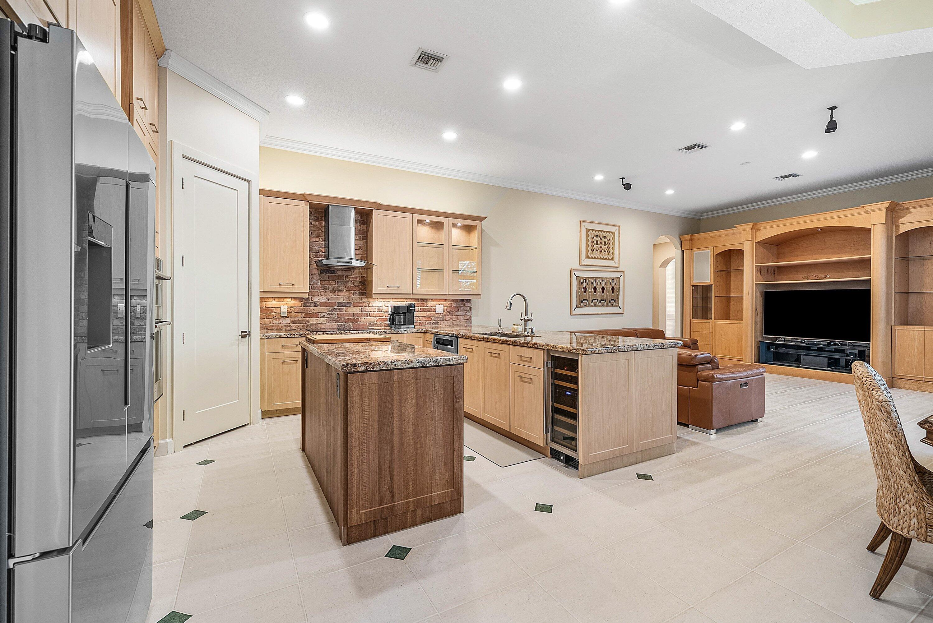 21374 Falls Ridge Way Boca Raton, FL 33428 - Photo 12 of 69 a kitchen with stainless steel appliances kitchen island granite countertop a stove and a refrigerator