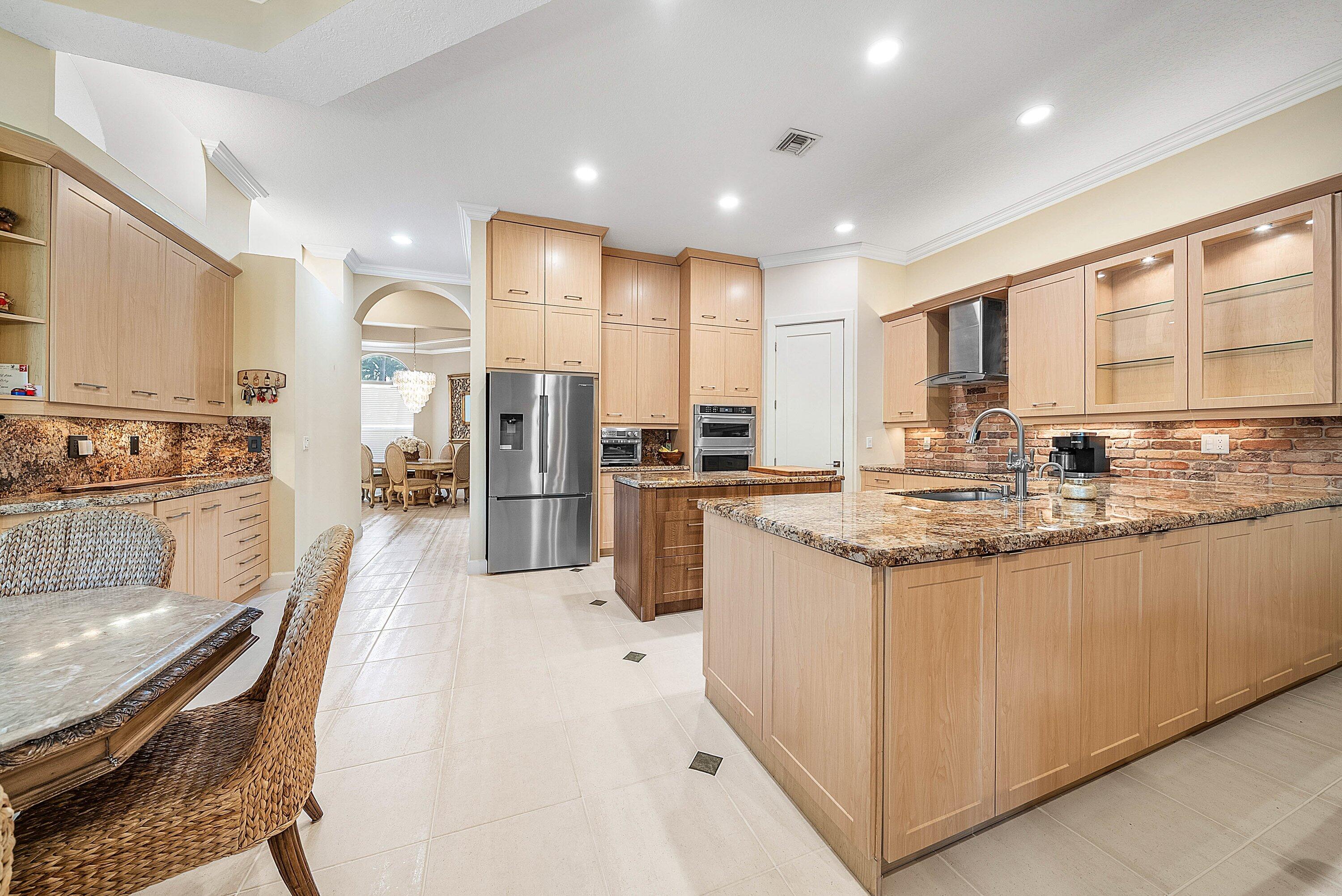 21374 Falls Ridge Way Boca Raton, FL 33428 - Photo 13 of 69 a kitchen with stainless steel appliances granite countertop a stove top oven a refrigerator a sink and white cabinets