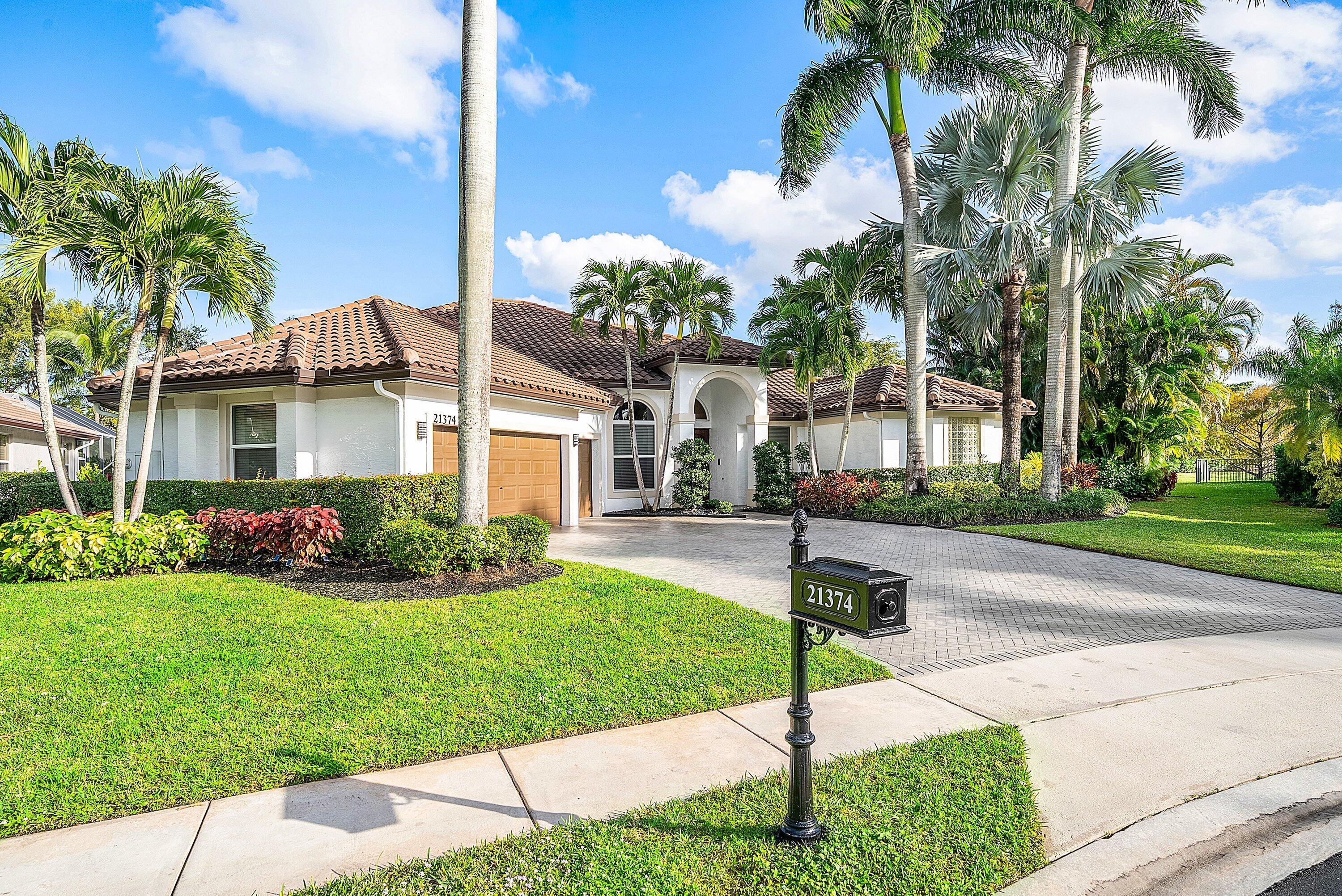 21374 Falls Ridge Way Boca Raton, FL 33428 - Photo 2 of 69 a front view of a house with a yard and potted plants