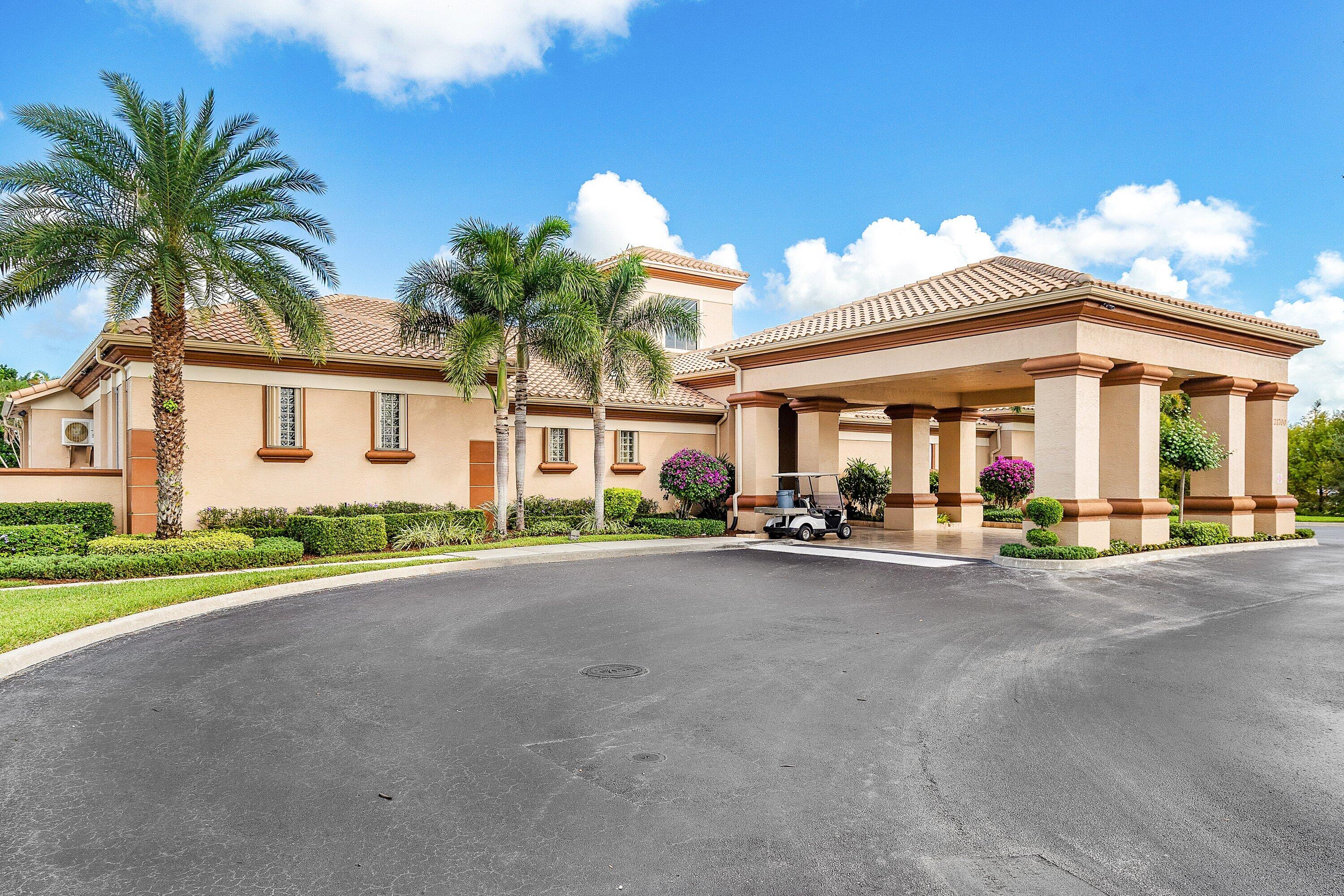21374 Falls Ridge Way Boca Raton, FL 33428 - Photo 50 of 69 a view of a white house with swimming pool lawn chairs and a small yard