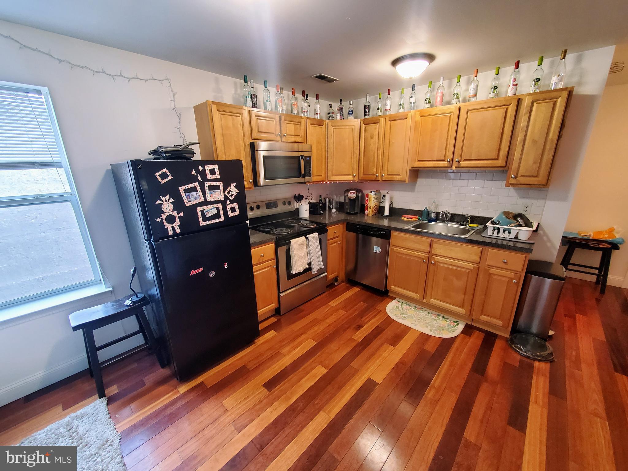 1525 North 17th Street, Unit 3 Philadelphia, PA 19121 - Photo 4 of 10 a kitchen with granite countertop a refrigerator stove and sink