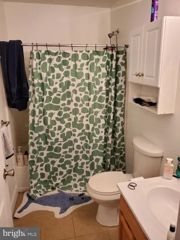 a bathroom with a toilet and a shower curtain