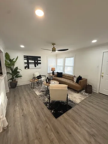 a living room with furniture and a wooden floor