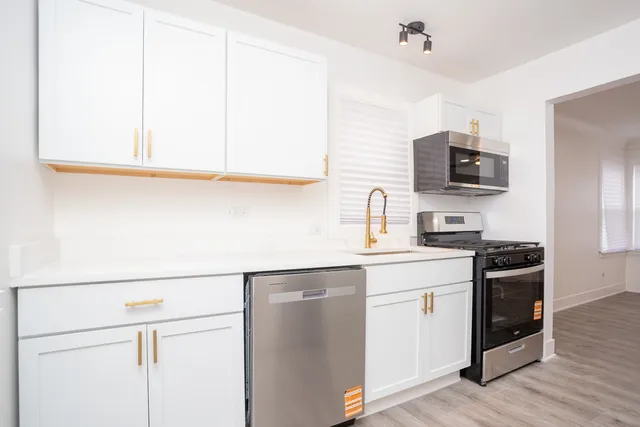 a kitchen with stainless steel appliances granite countertop a sink and a stove