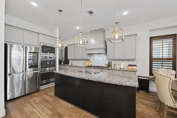a kitchen with kitchen island granite countertop wooden cabinets and white appliances