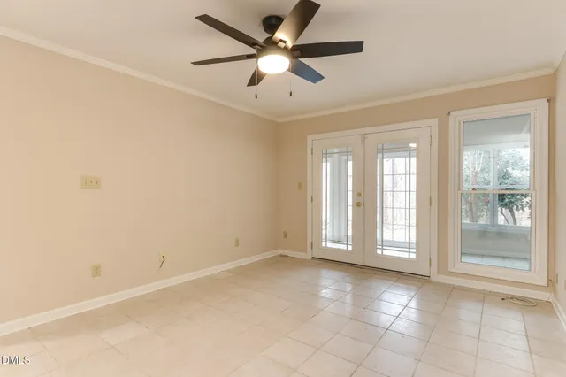 a bedroom with a large bed and a chandelier fan