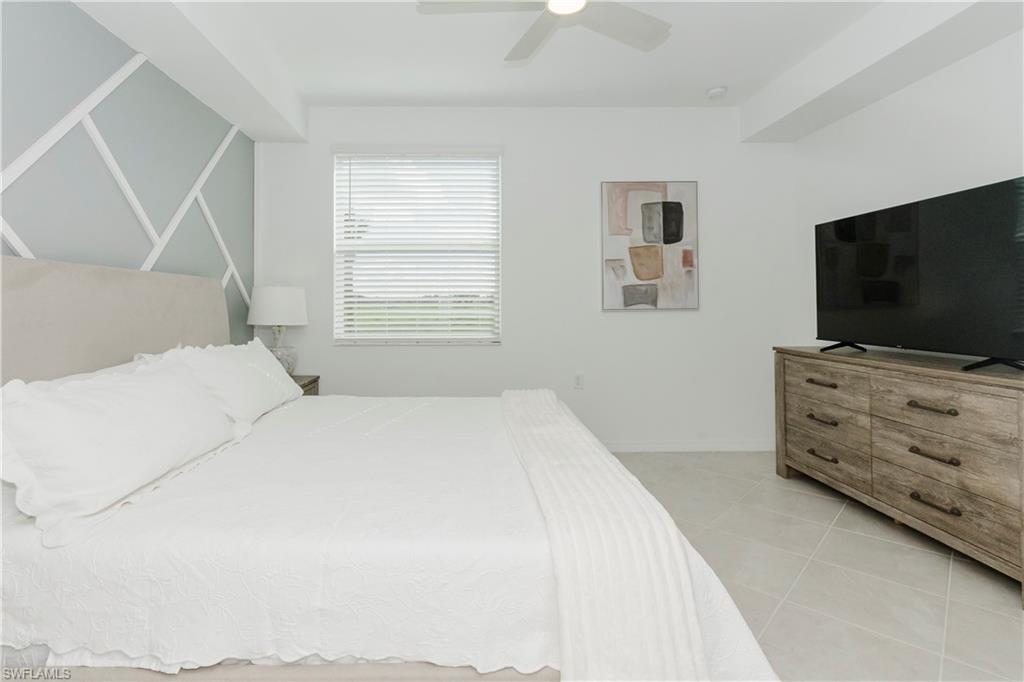 15285 Grn Acrs Avenue, Unit 418 Babcock Ranch, FL 33982 - Photo 14 of 49 a bedroom with a bed and a flat screen tv