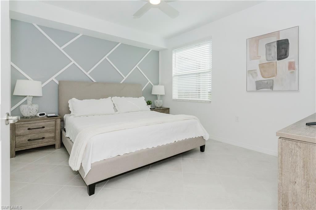 15285 Grn Acrs Avenue, Unit 418 Babcock Ranch, FL 33982 - Photo 15 of 49 a large bed sitting in a bedroom next to a window with a dresser
