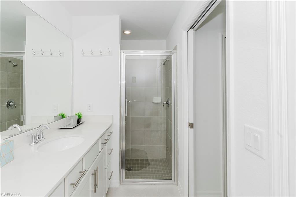 15285 Grn Acrs Avenue, Unit 418 Babcock Ranch, FL 33982 - Photo 18 of 49 a bathroom with a bathtub shower sink and mirror