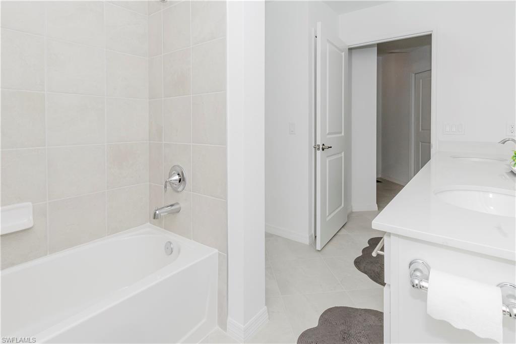15285 Grn Acrs Avenue, Unit 418 Babcock Ranch, FL 33982 - Photo 24 of 49 a white bath tub sitting next to a white sink