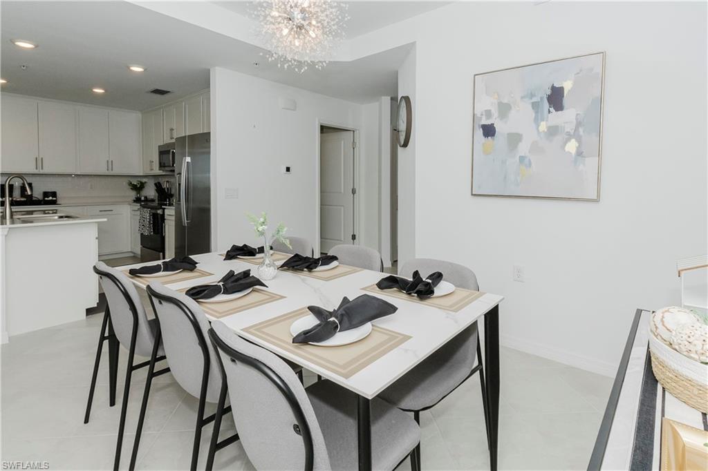 15285 Grn Acrs Avenue, Unit 418 Babcock Ranch, FL 33982 - Photo 5 of 49 a view of a dining room with furniture and a chandelier